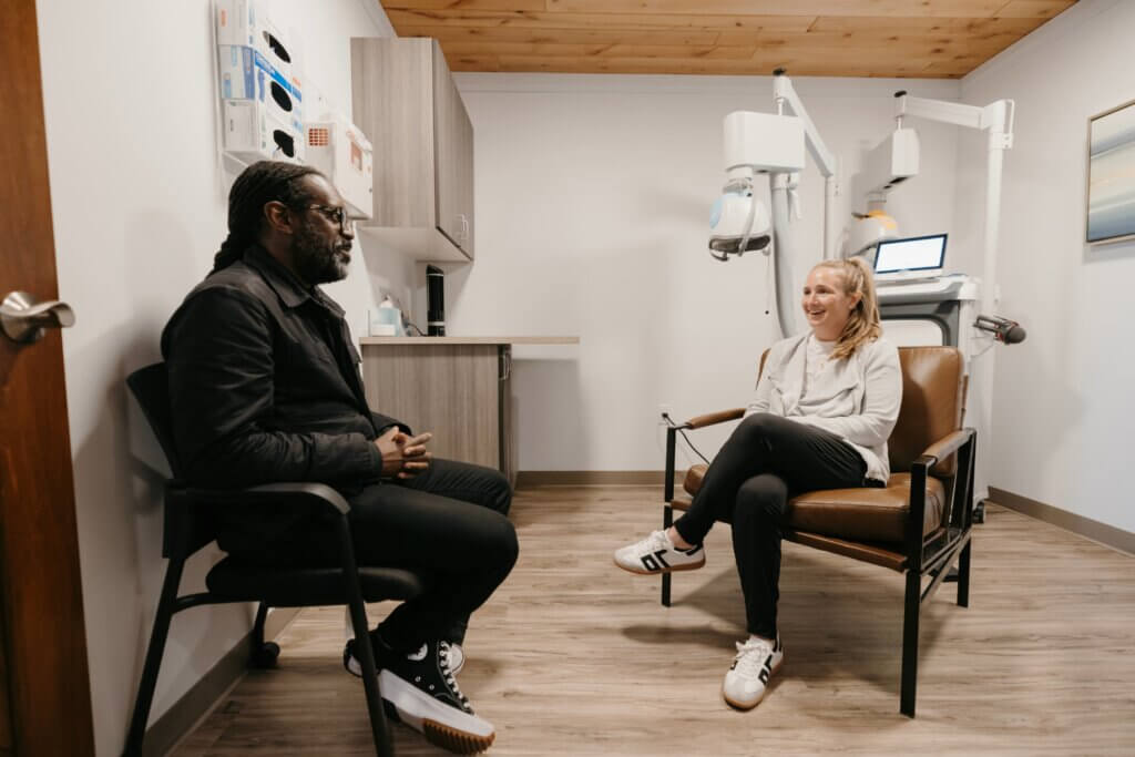 Patient speaking with a psychiatrist beside a Deep TMS machine at The Remedy Mental Health