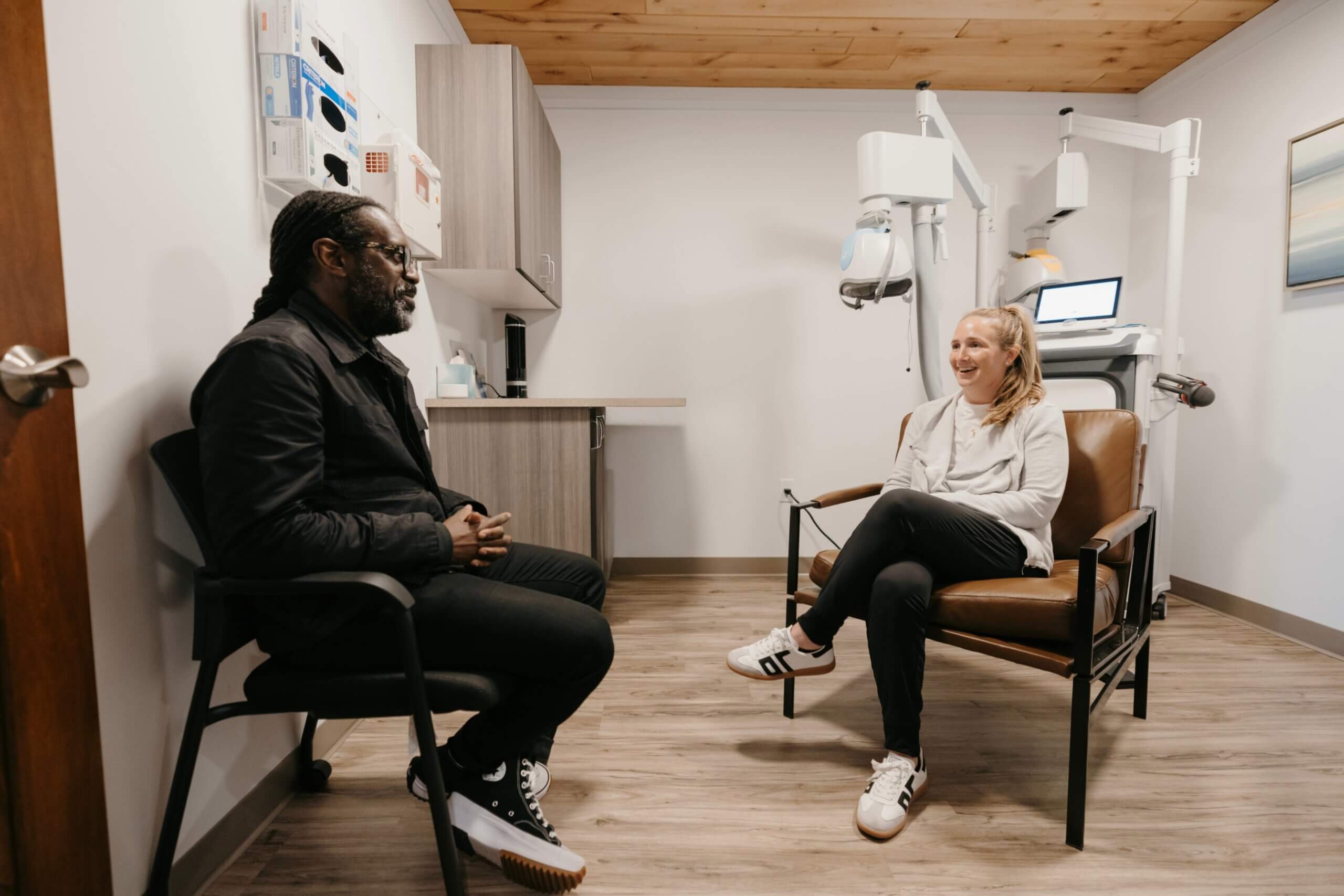 Patient speaking with a psychiatrist beside a Deep TMS machine at The Remedy Mental Health